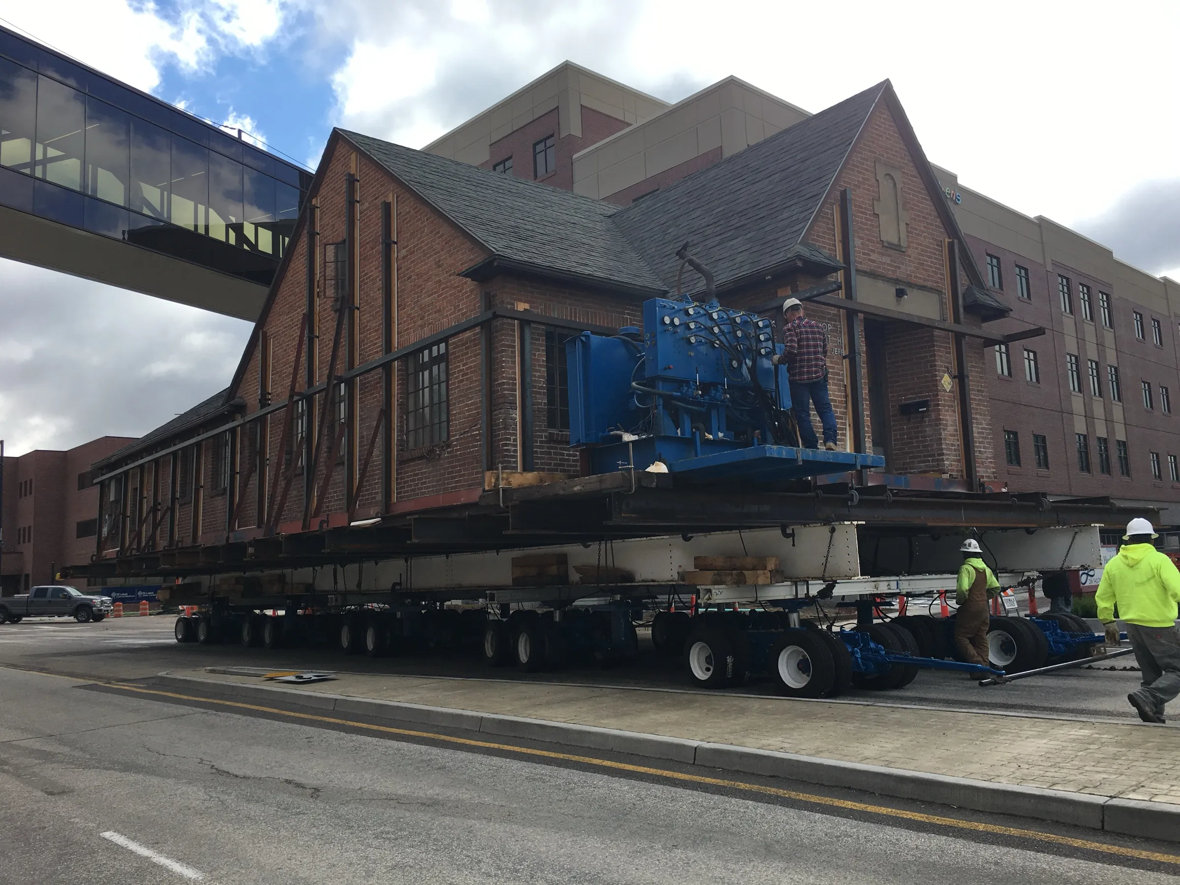 Hydraulic power unit and crew guiding the building past a hospital tower