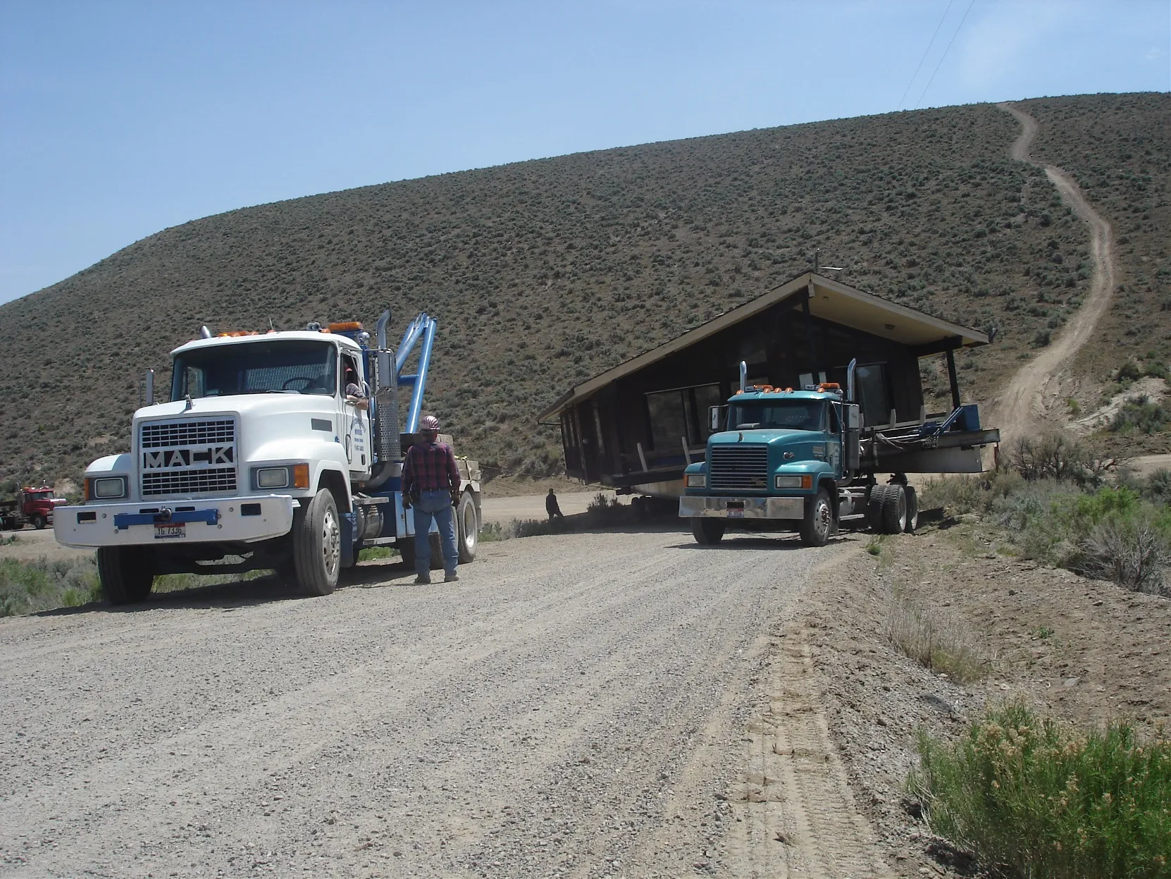 Two trucks hauling the house in transit