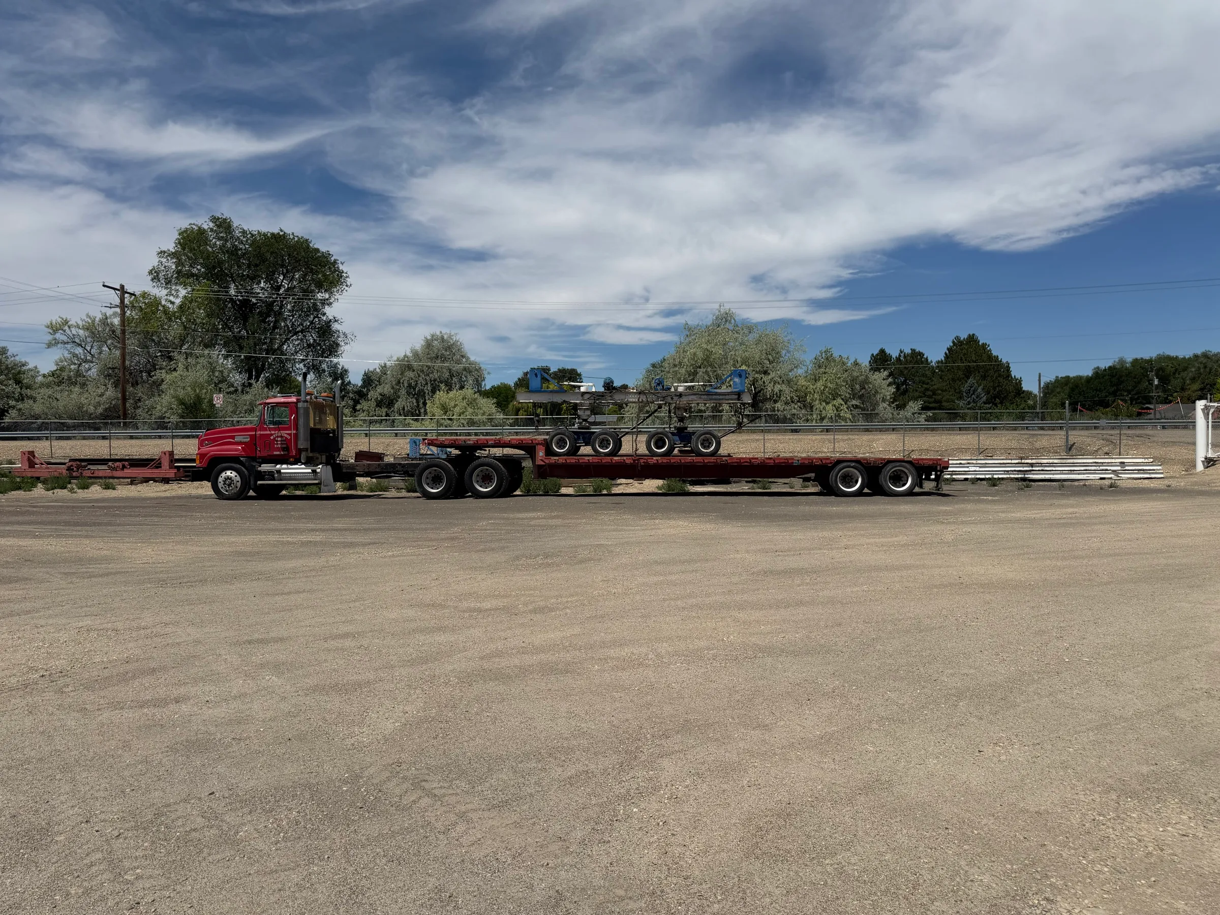 Western States Movers truck and flatbed trailer loaded with hydraulic dollies