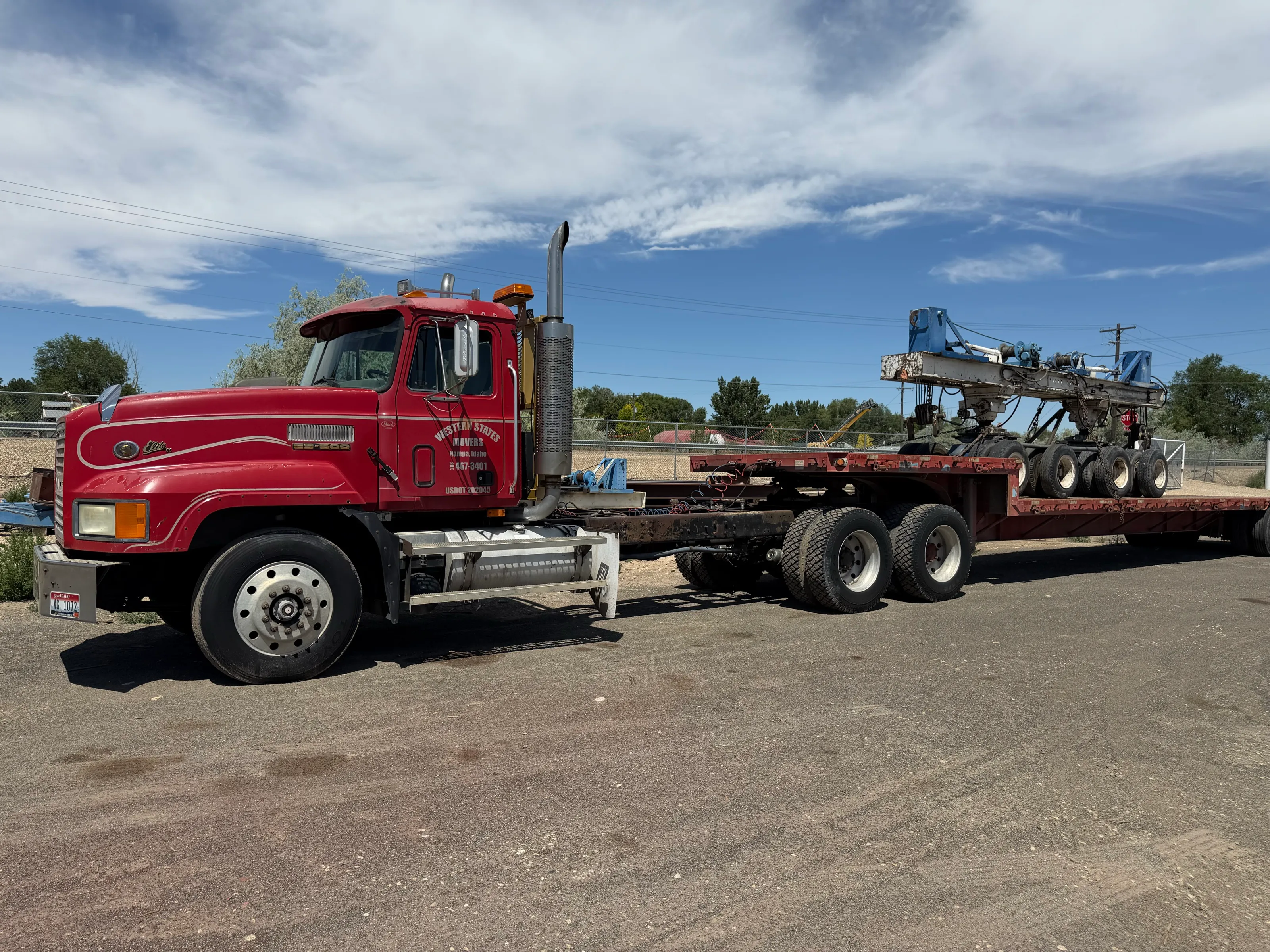 Western States Movers truck and flatbed trailer loaded with hydraulic dollies