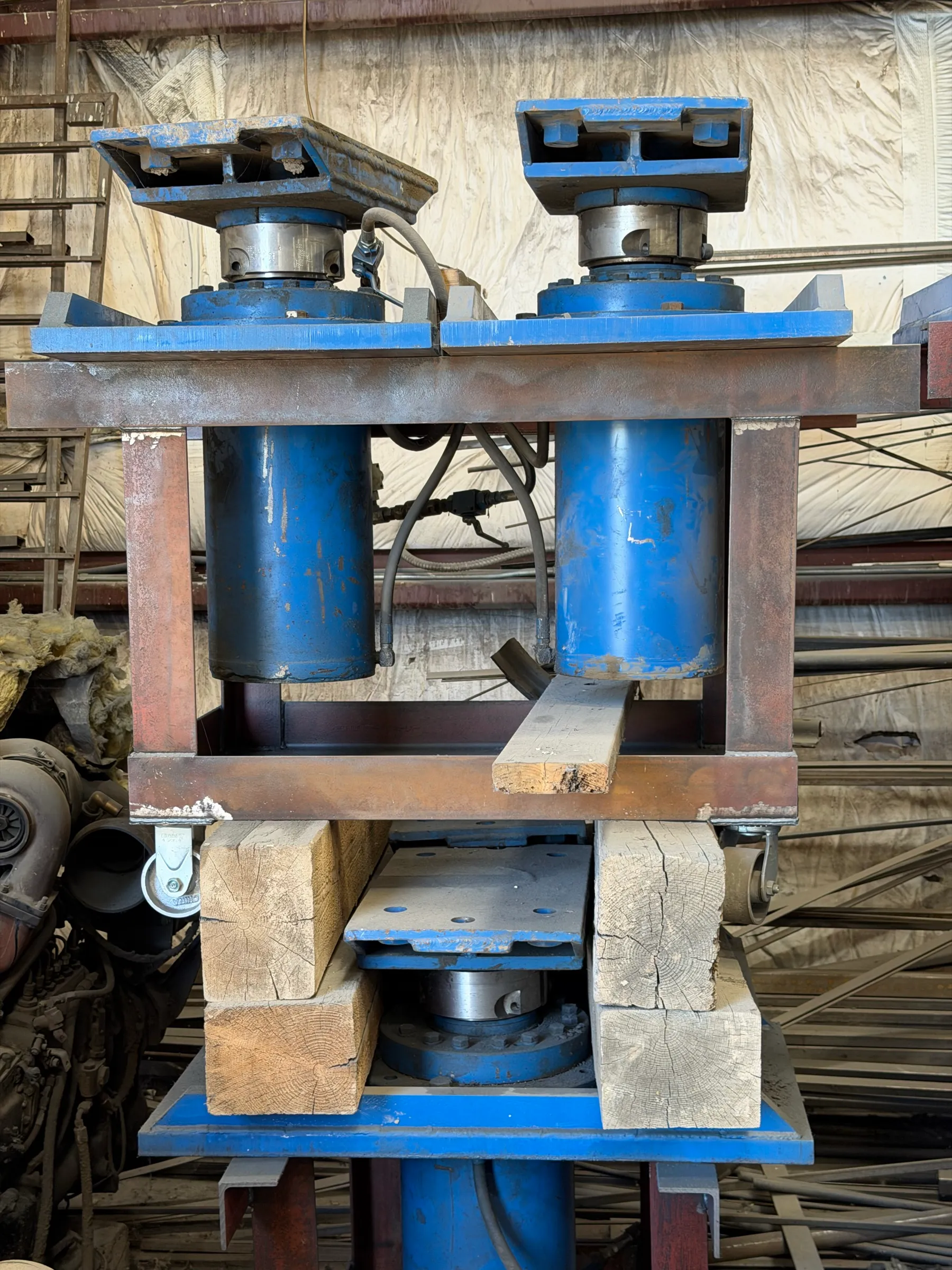 Twin hydraulic ram jacks in their steel jacking frame over cribbing