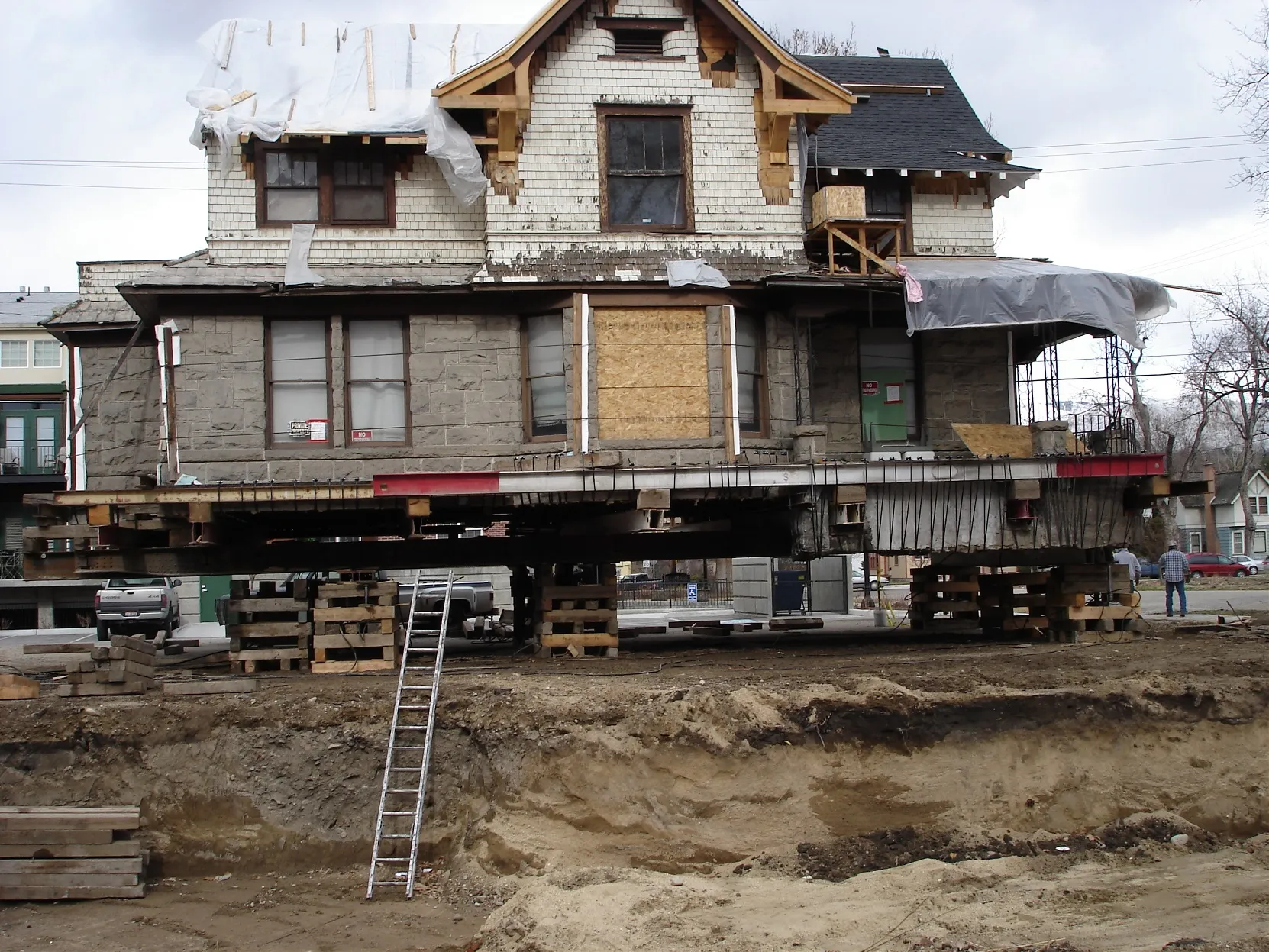 A Victorian house on steel beams over an excavated pad