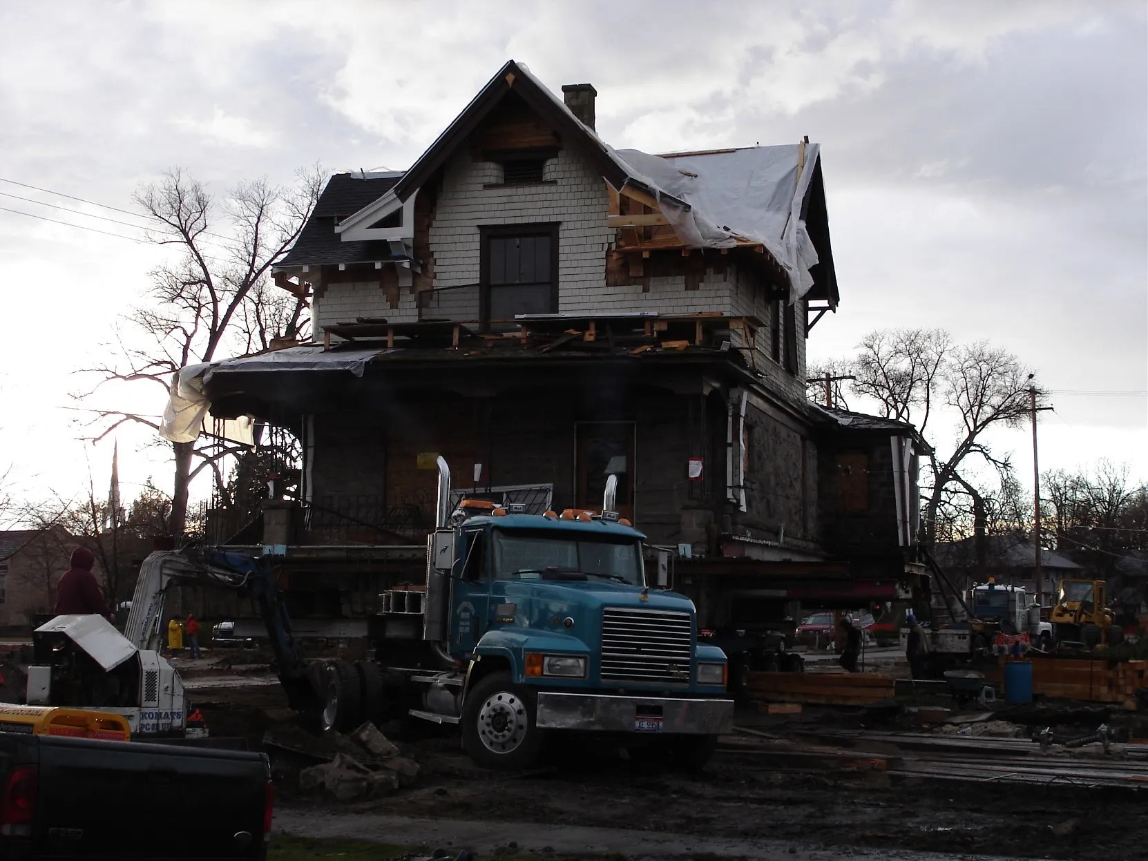 Weathered Victorian house in mid-move on a trailer