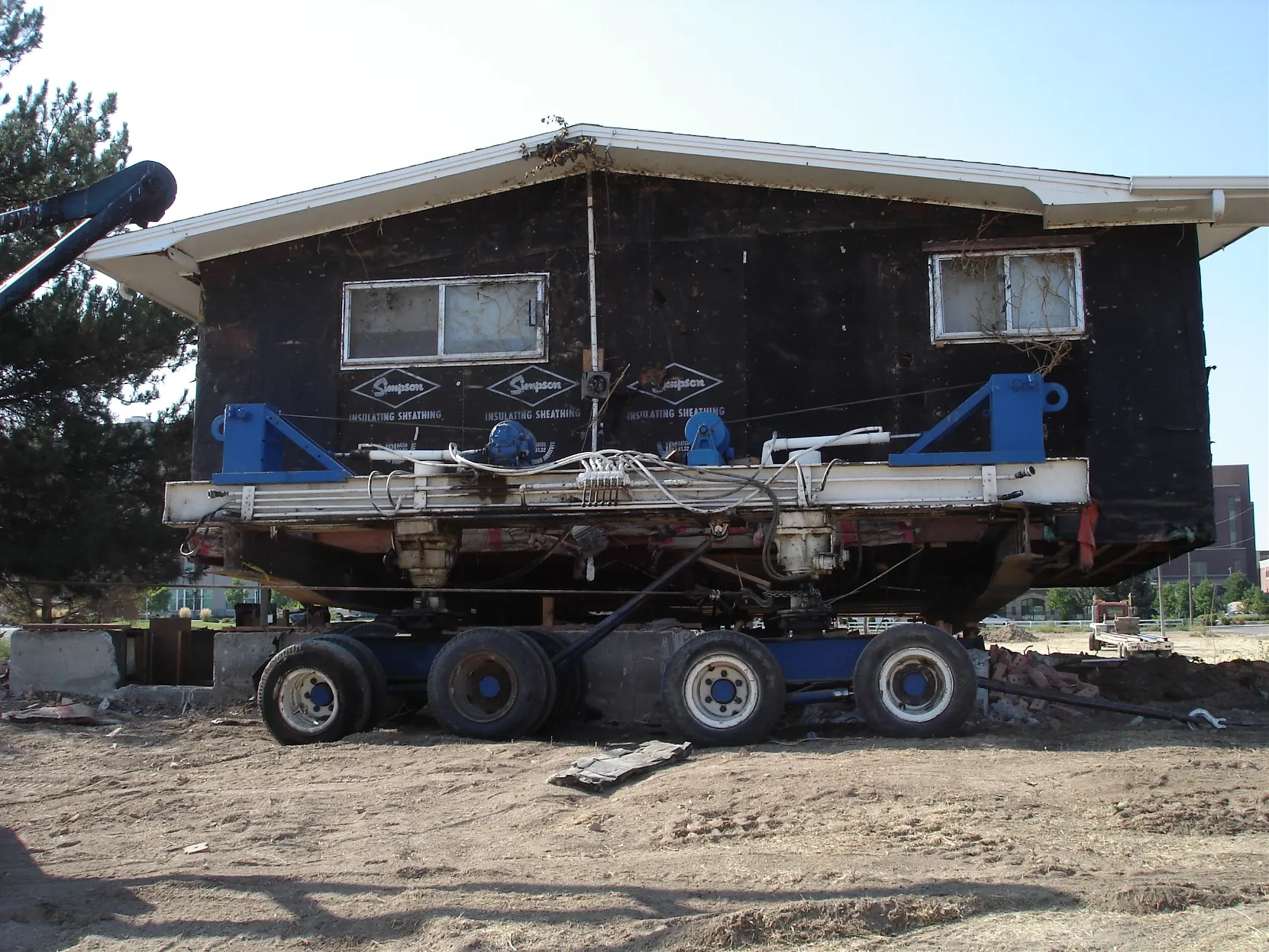 Dark metal building on hydraulic dollies